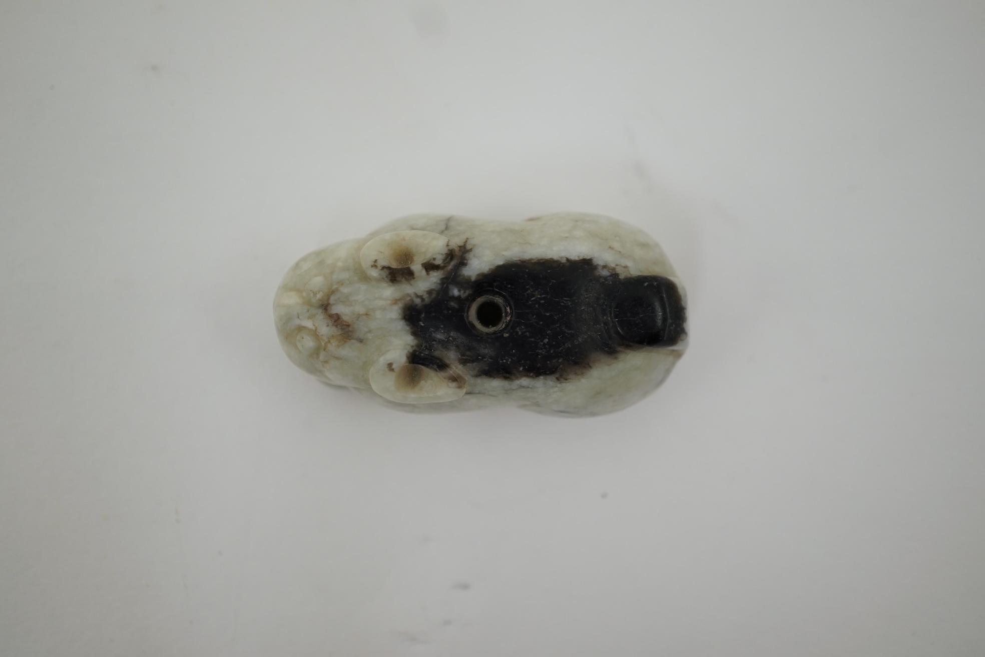 A Chinese white and black jade figure of a recumbent tiger, Song dynasty